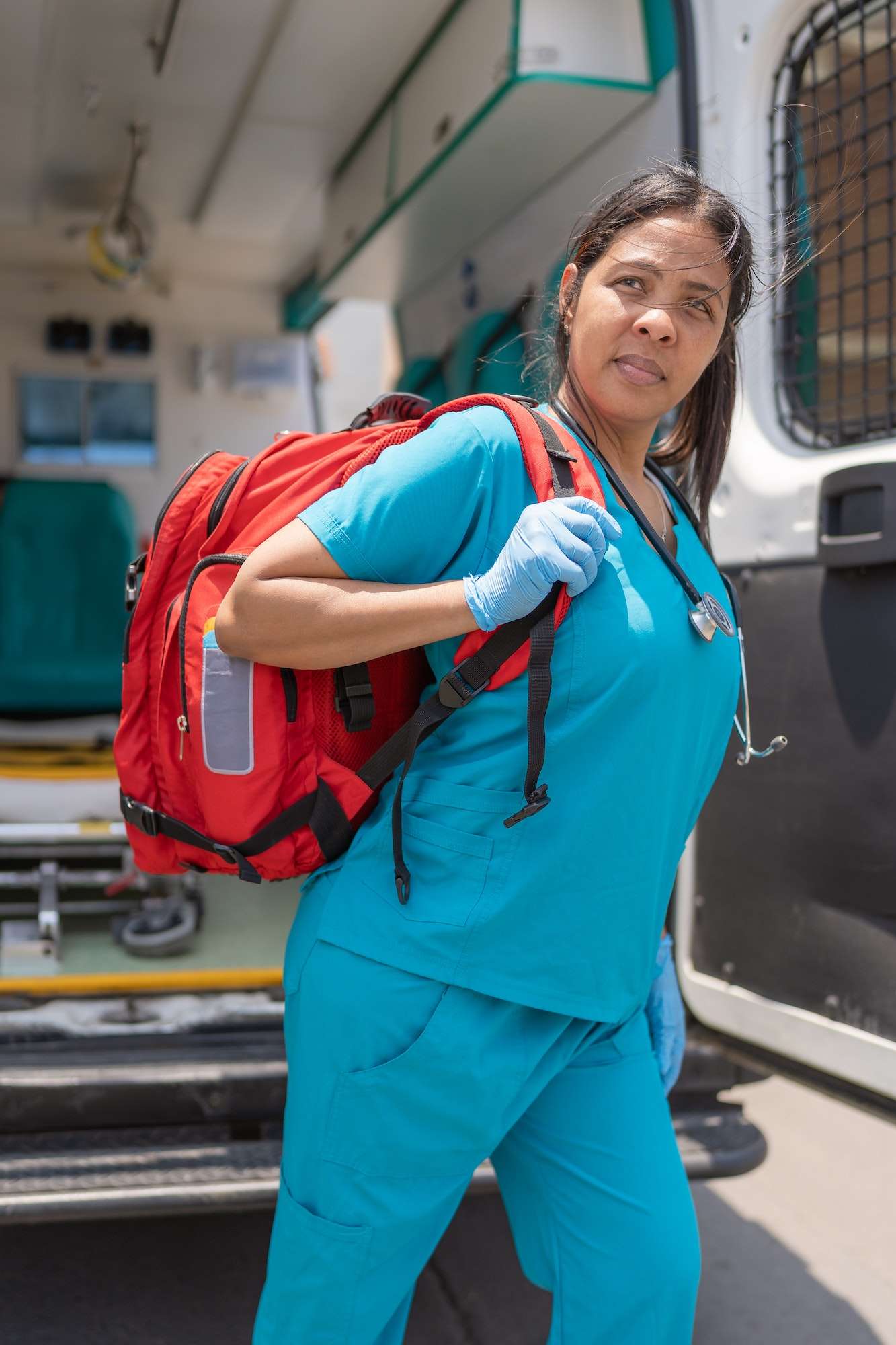 Vertical photo of a health technician in a hurry carrying a first-aid kit